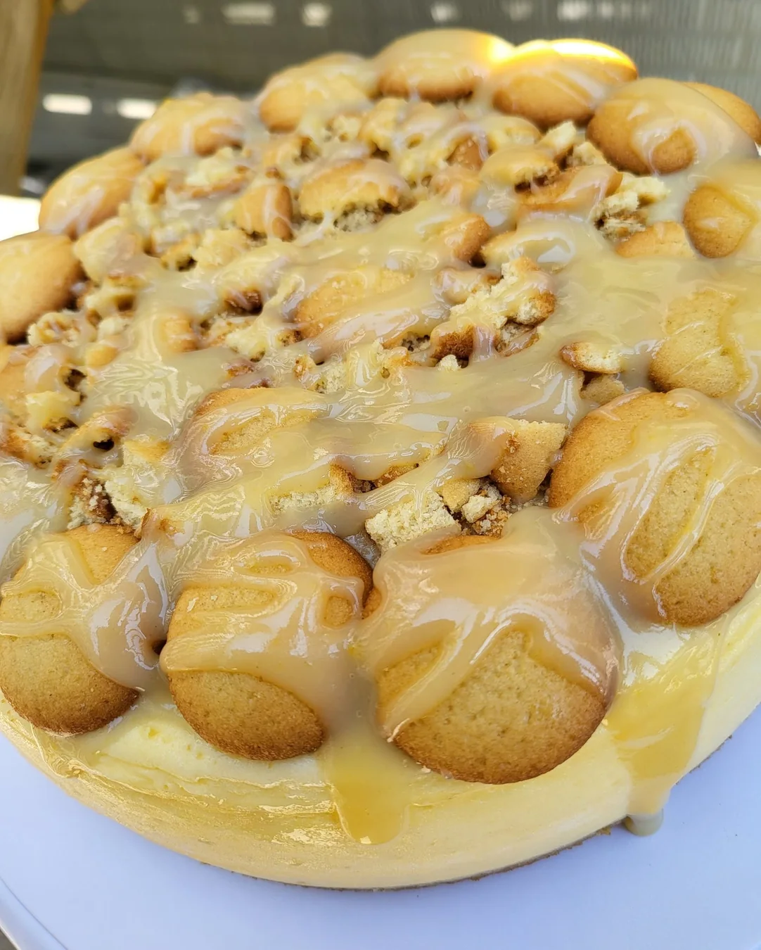 A whole cheesecake piled with golden cookies and a rich drizzle